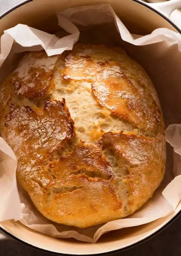 Crusty artisan bread in a Dutch oven, golden and freshly baked.