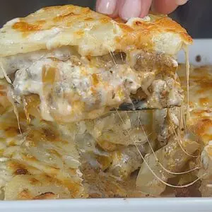 Cheesy beef and potato casserole served hot in a baking dish, topped with melted golden cheese.